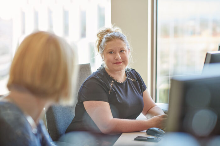 Medarbetare och student i samtal vid arbetsplats.