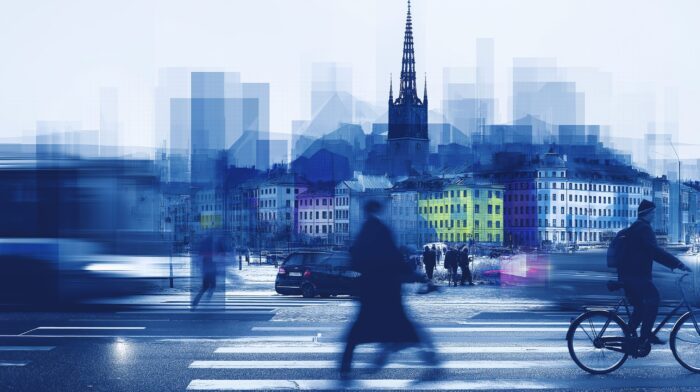 En stadsbild med bilar och m&auml;nniskor som r&ouml;r sig snabbt