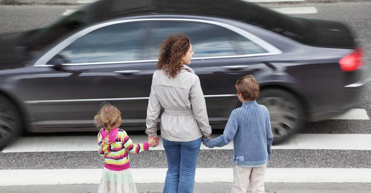 mamma med barn v&auml;ntar vid &ouml;verg&aring;ngsst&auml;lle