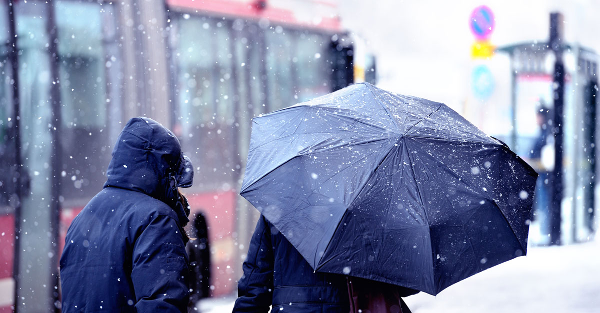Två resenärer väntar på att få gå på bussen.
